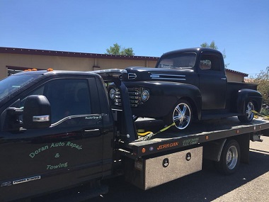 black antique truck on flatbed tow truck
